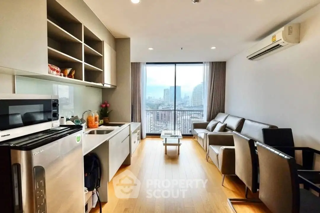 Modern living room with city view, sleek furniture, and open kitchen layout.