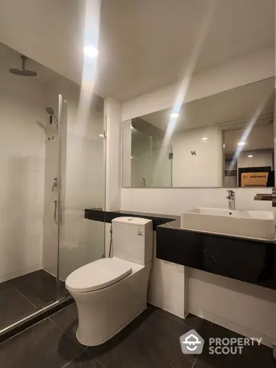 Modern bathroom with sleek design featuring glass shower and elegant fixtures.