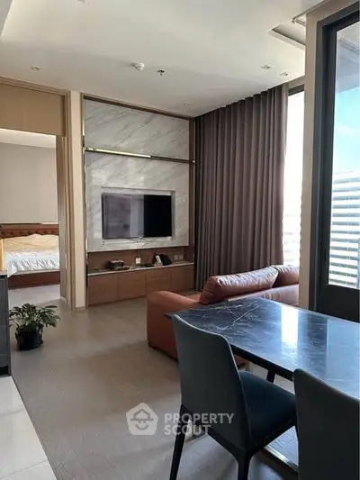 Modern living room with sleek furniture and large window offering natural light