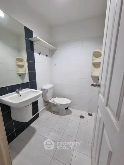 Compact bathroom with white tiles and modern fixtures