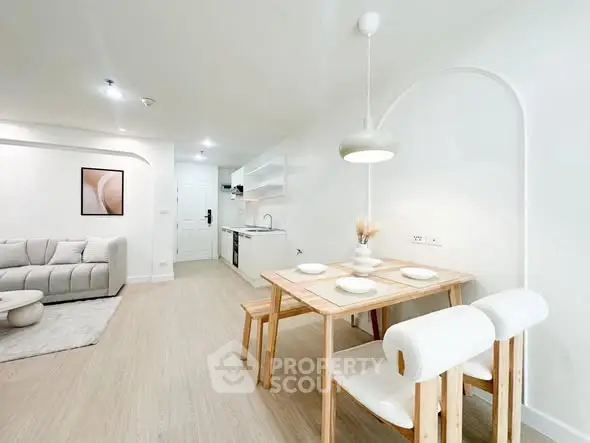 Modern open-plan living room and kitchen with minimalist decor and natural light.
