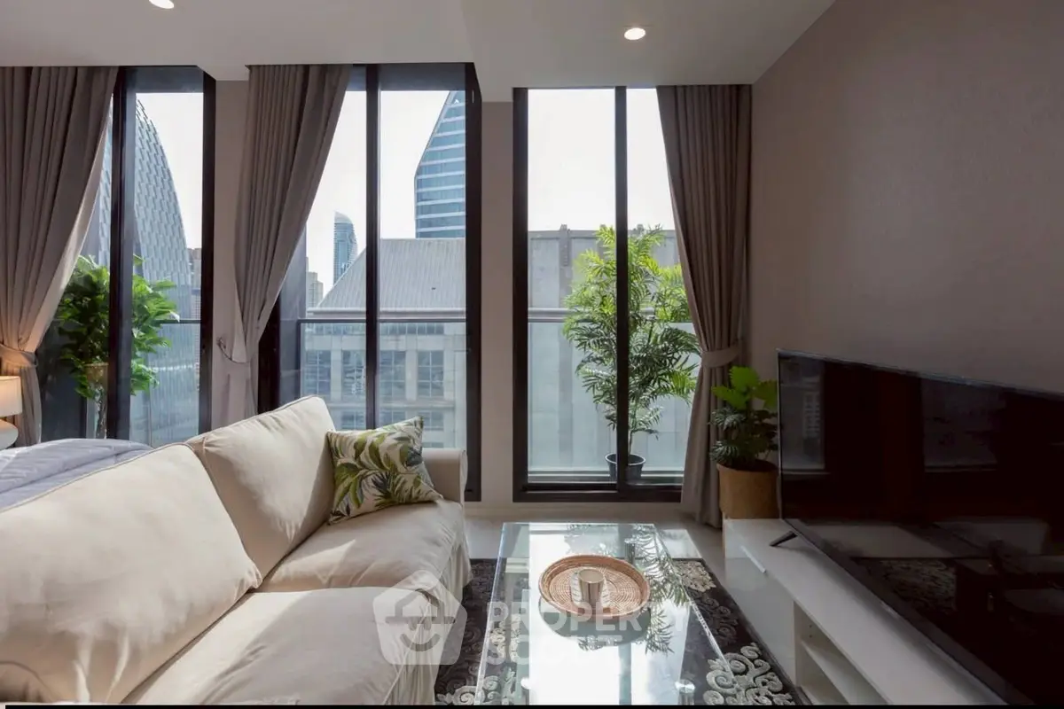Modern living room with large windows and city view, featuring a cozy sofa and stylish decor.