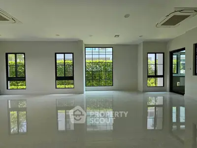 Spacious modern living room with large windows and glossy floors