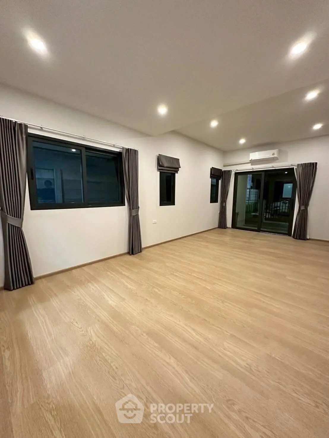 Spacious modern living room with wooden flooring and large windows