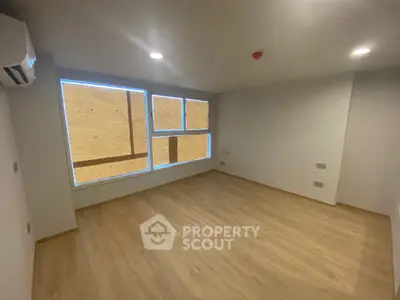 Spacious unfurnished room with large windows and wooden flooring