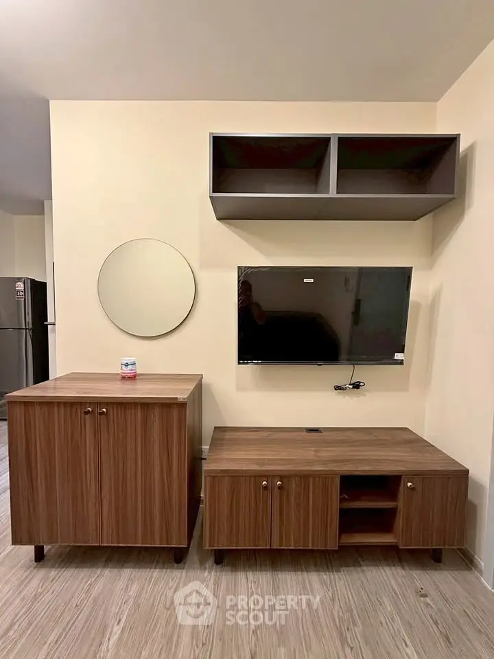 Modern living room with stylish wooden furniture and mounted TV, perfect for cozy urban living.