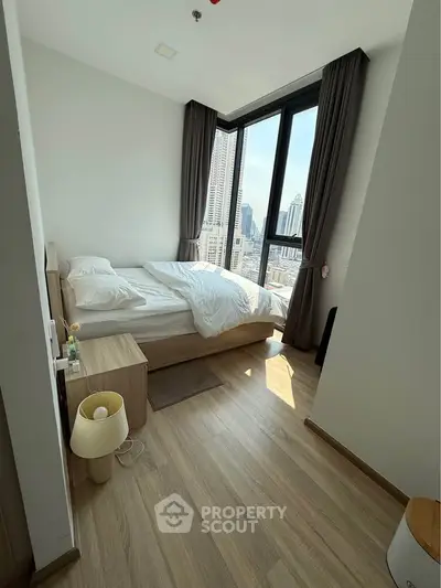 Modern bedroom with city view, large windows, and minimalist decor in a high-rise apartment.