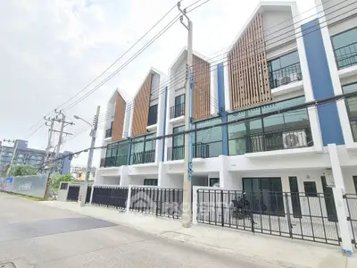 Modern townhouse exterior with sleek design and large windows in a vibrant neighborhood.