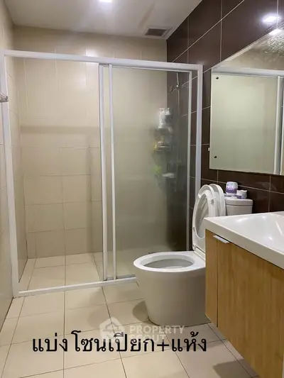 Modern bathroom with glass shower enclosure and sleek vanity.