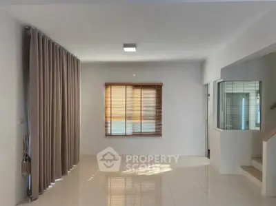 Spacious modern living room with large windows and elegant curtains