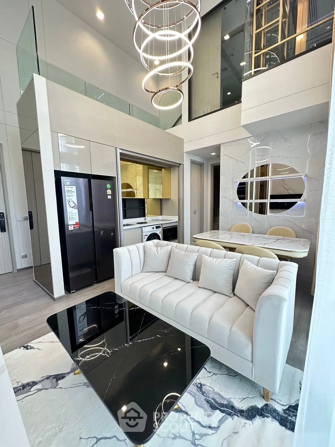Luxurious modern living room with high ceilings, elegant chandelier, and stylish furniture in a contemporary apartment.