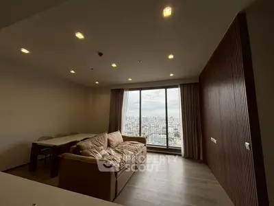 Spacious living room with panoramic city view and cozy seating area.