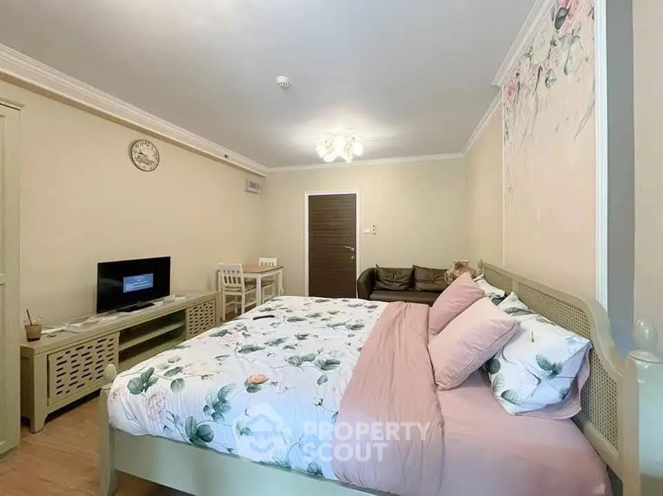 Cozy bedroom with floral bedding and modern decor in a stylish apartment.