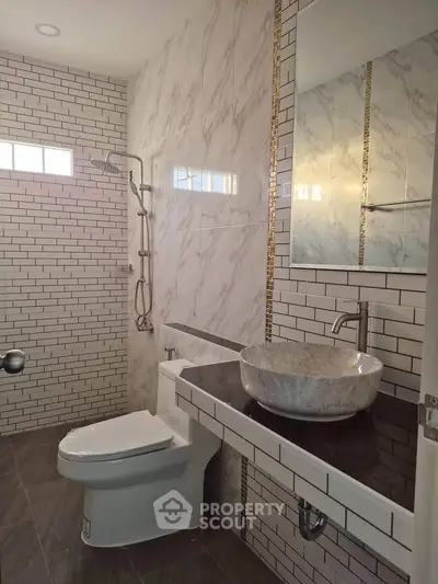 Modern bathroom with stylish marble sink and sleek shower design