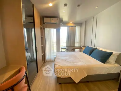 Modern bedroom with large windows and stylish decor in a high-rise apartment.