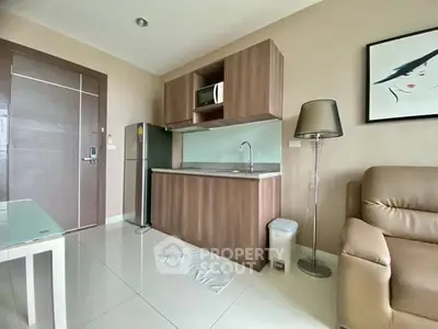 Modern compact kitchen with sleek cabinetry and stainless steel appliances in cozy apartment.