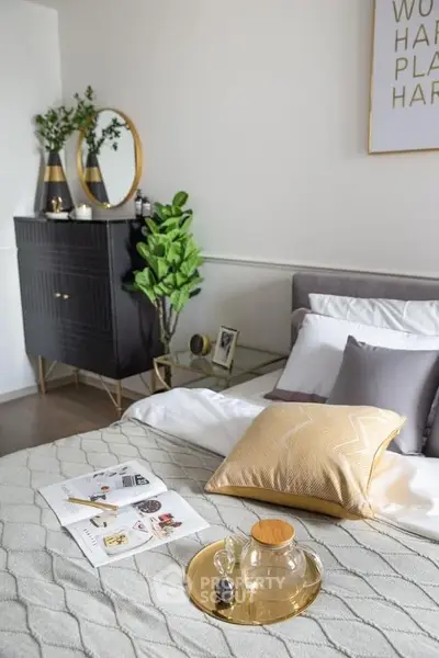 Elegant bedroom with stylish decor, featuring a cozy bed, modern dresser, and lush greenery for a serene ambiance.