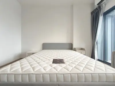Spacious bedroom with large bed and natural light from balcony window