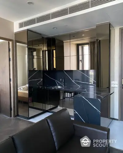 Luxurious modern living space with sleek black marble accents, mirrored walls, and contemporary furnishings, perfect for upscale urban living.