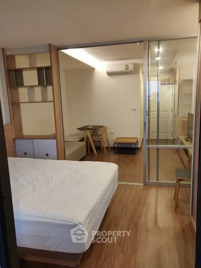 Modern studio apartment with wooden flooring and minimalist furniture