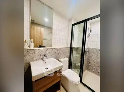 Modern bathroom with sleek shower and stylish sink in contemporary apartment.