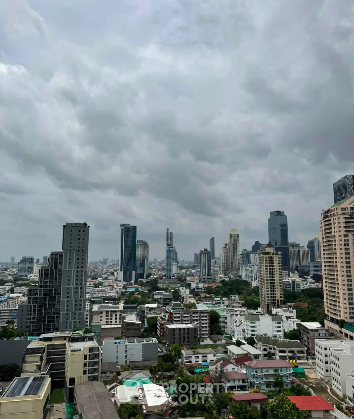 Stunning cityscape view showcasing a vibrant urban skyline with diverse architecture under a dramatic cloudy sky.