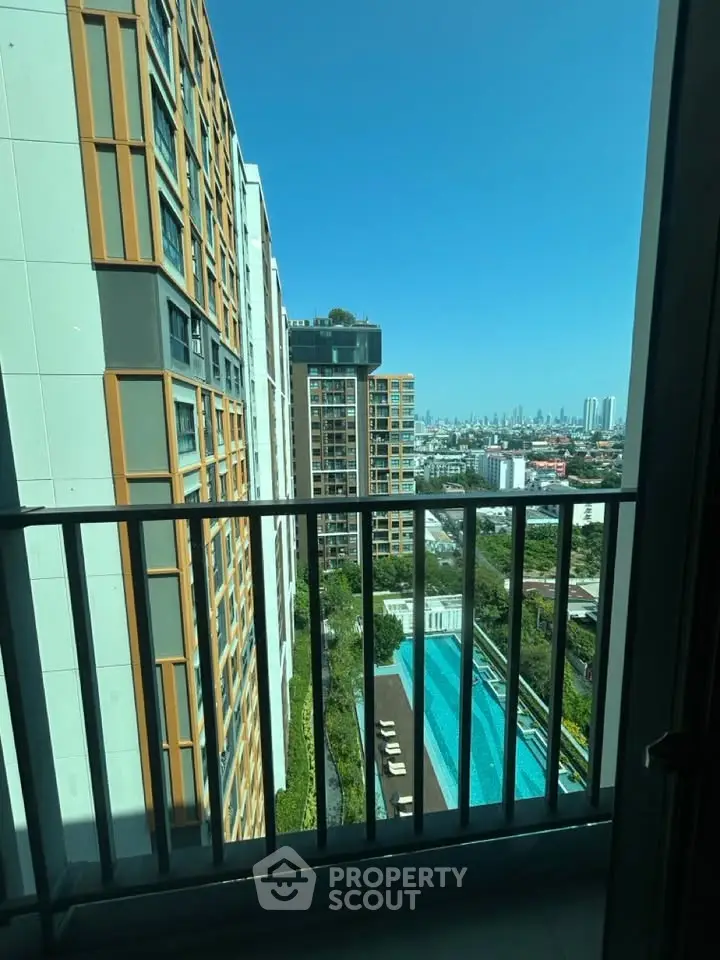 Stunning city view from high-rise balcony overlooking pool and skyline.