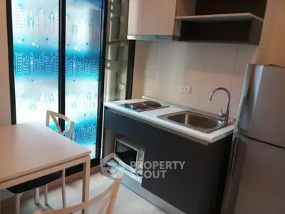 Modern compact kitchen with sleek appliances and city-themed window decor.