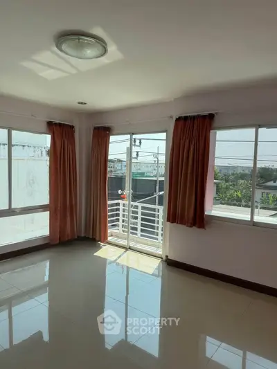 Bright corner unit with large windows and balcony access, offering ample natural light and city views.