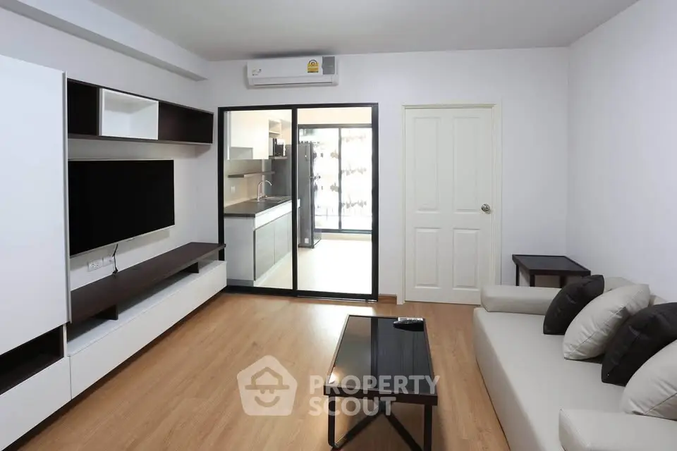 Modern living room with sleek furniture and open kitchen layout, perfect for contemporary living.