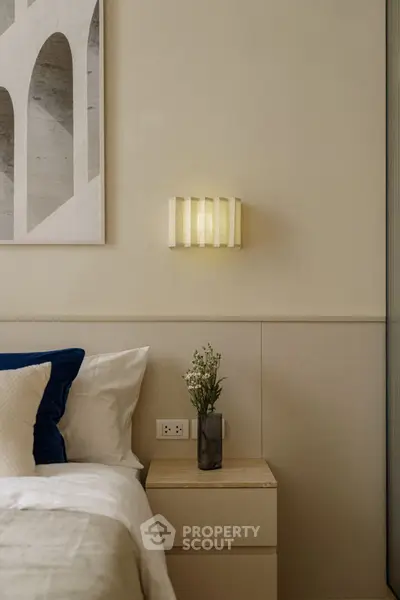 Elegant bedroom with modern wall art and cozy lighting, perfect for relaxation.