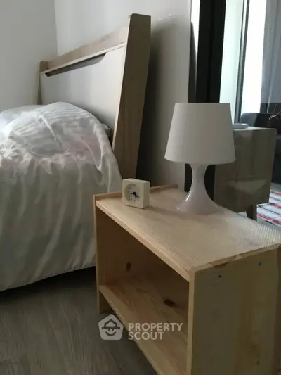 Cozy bedroom with modern wooden bed and stylish lamp on bedside table.