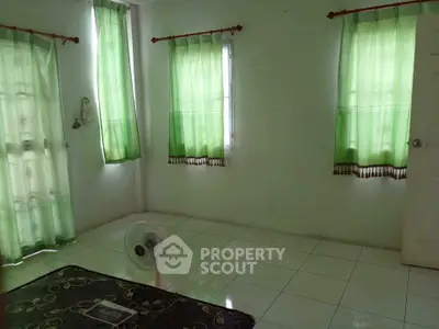 Spacious room with green curtains and tiled floor, ideal for customization.