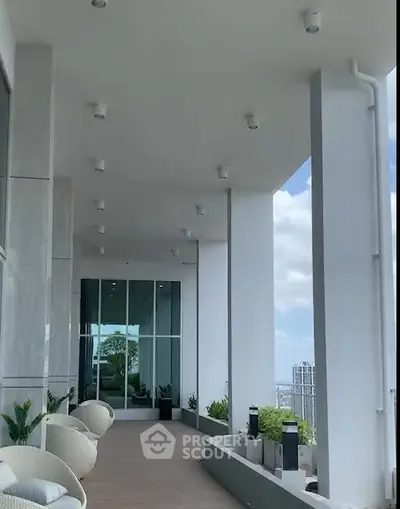 Luxurious high-rise balcony with modern seating and panoramic city views.