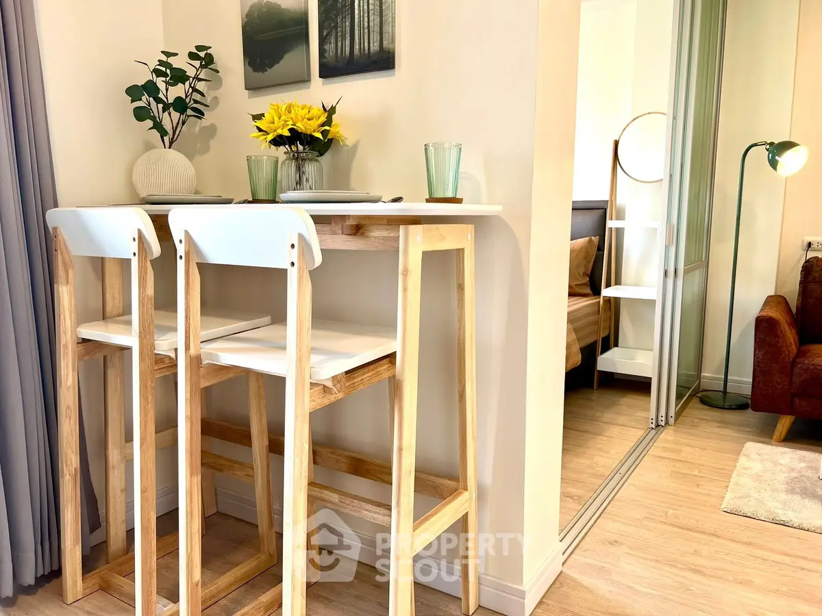 Chic modern apartment interior with stylish bar stools and cozy bedroom view.
