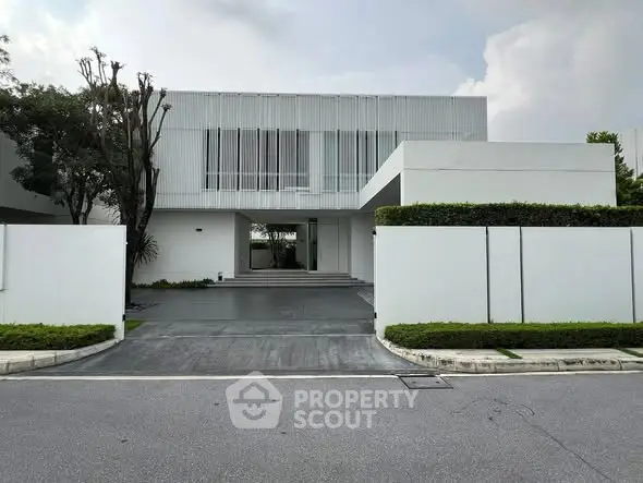 Modern minimalist white building with sleek design and lush greenery