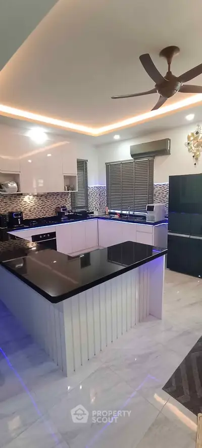 Modern kitchen with sleek black countertops and ambient lighting