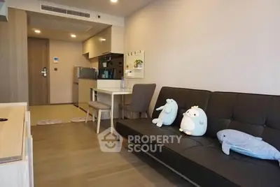 Modern living room with cozy sofa and open kitchen layout in a stylish apartment.