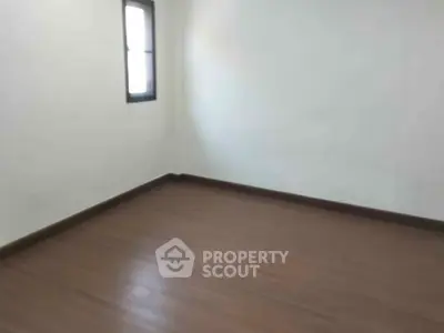 Spacious empty room with wooden flooring and natural light