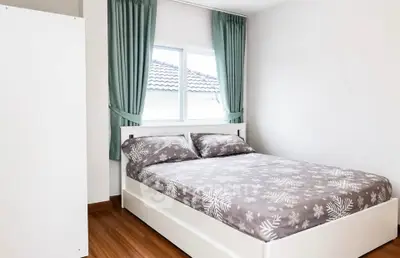 Cozy bedroom with modern decor and natural light, perfect for relaxation.