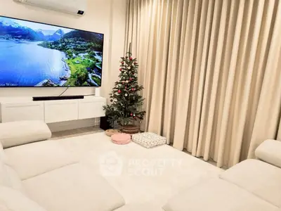 Cozy living room with modern decor and large TV, perfect for relaxation.