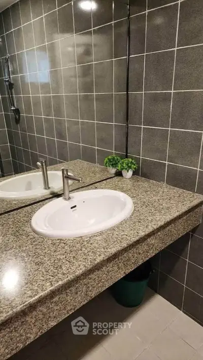 Modern bathroom with granite countertop and stylish sink in a contemporary home.