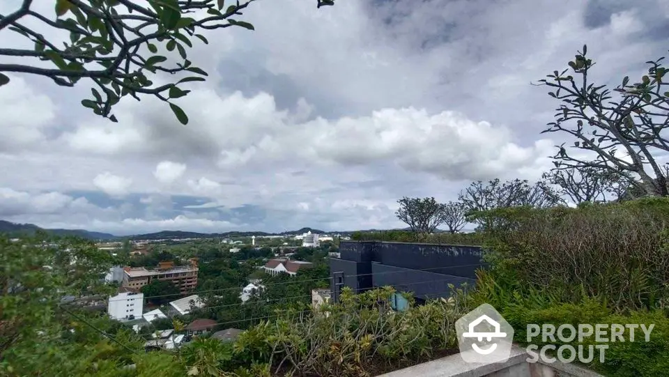 Stunning panoramic view from rooftop garden overlooking lush landscape and city skyline.