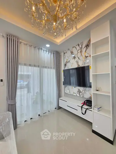 Elegant living room with chandelier, marble accent wall, and modern TV setup.