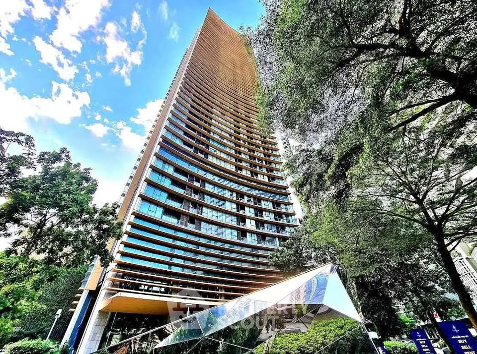 Stunning modern high-rise building with unique architectural design and lush greenery surroundings.