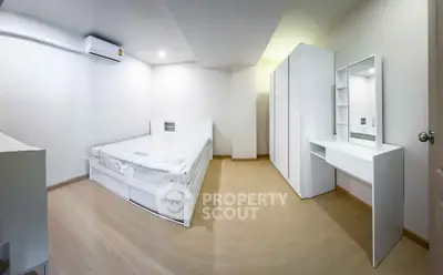 Spacious modern bedroom with minimalist white furniture and ample storage space.