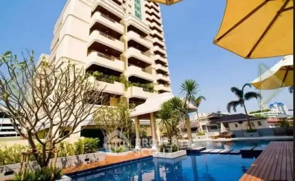 Luxurious apartment building with pool and lush landscaping in a prime urban location.