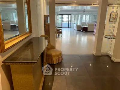 Spacious open-plan living area with elegant decor and large windows.