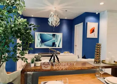 Stylish living room with modern decor, blue accent wall, and elegant dining setup.