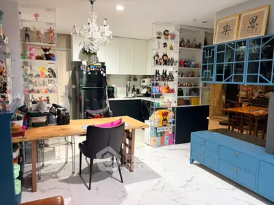 Stylish kitchen with open layout and modern decor, featuring a dining area and unique collectibles display.